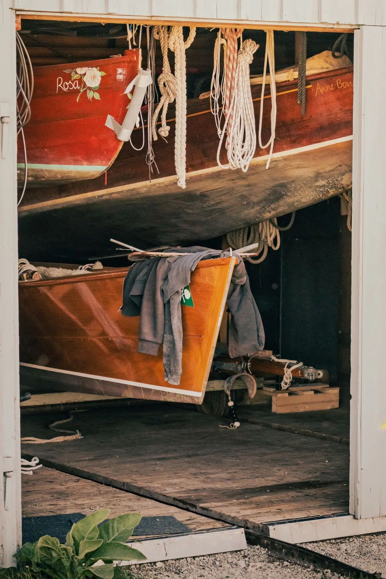 Classic wooden boats stored indoors in a boat shed