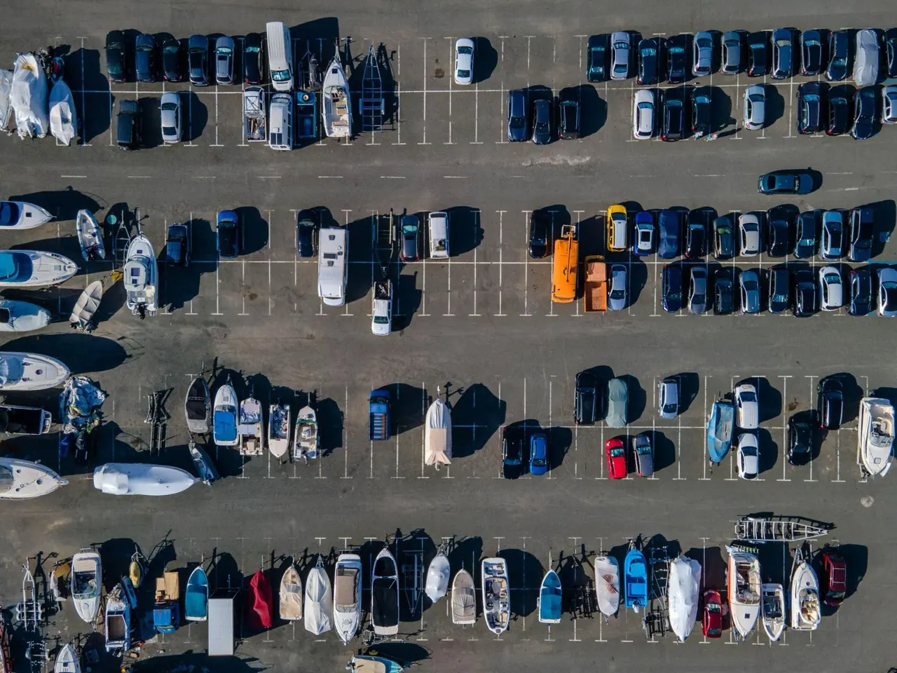 Boats on trailers and cars in a parking lot seen from above
